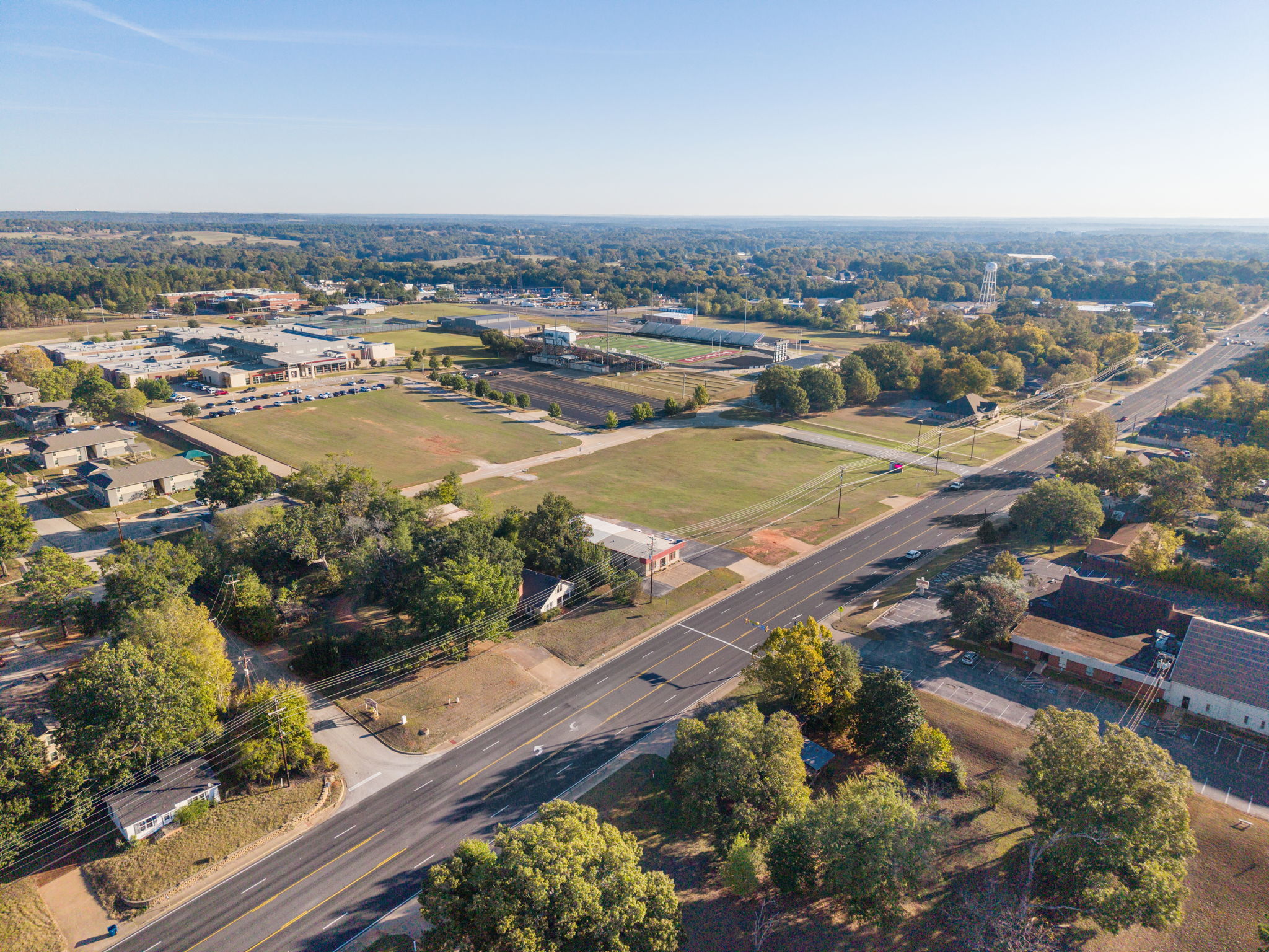 Wide aerial view along W. Main Street (FM 346) in Whitehouse, Texas, showing the surrounding neighborhood, school campus and athletic fields.