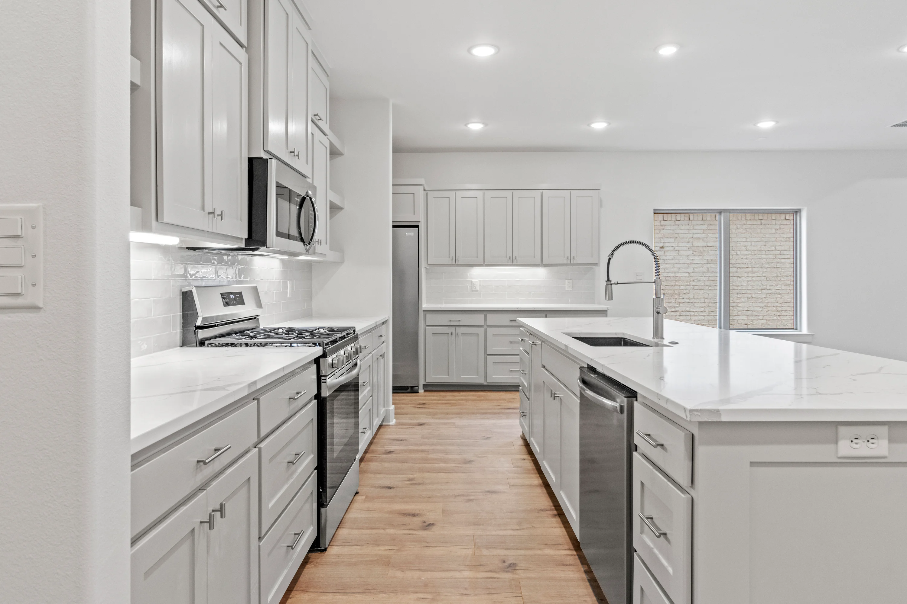 Open dining and living area adjoining the kitchen island inside the 2023 duplex.