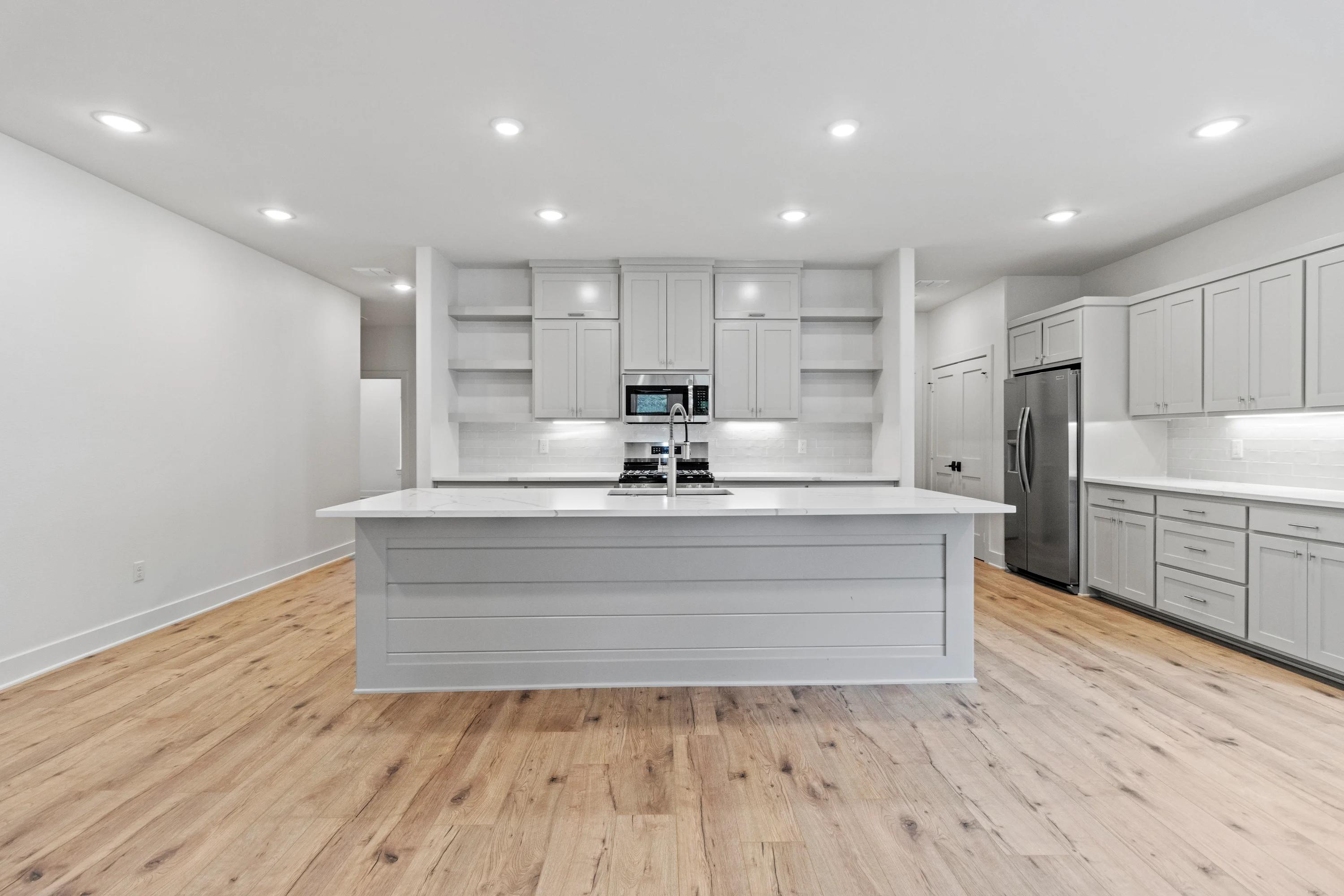 Open living area with high ceilings and abundant natural light inside a 6858 Lazy Vale duplex residence.