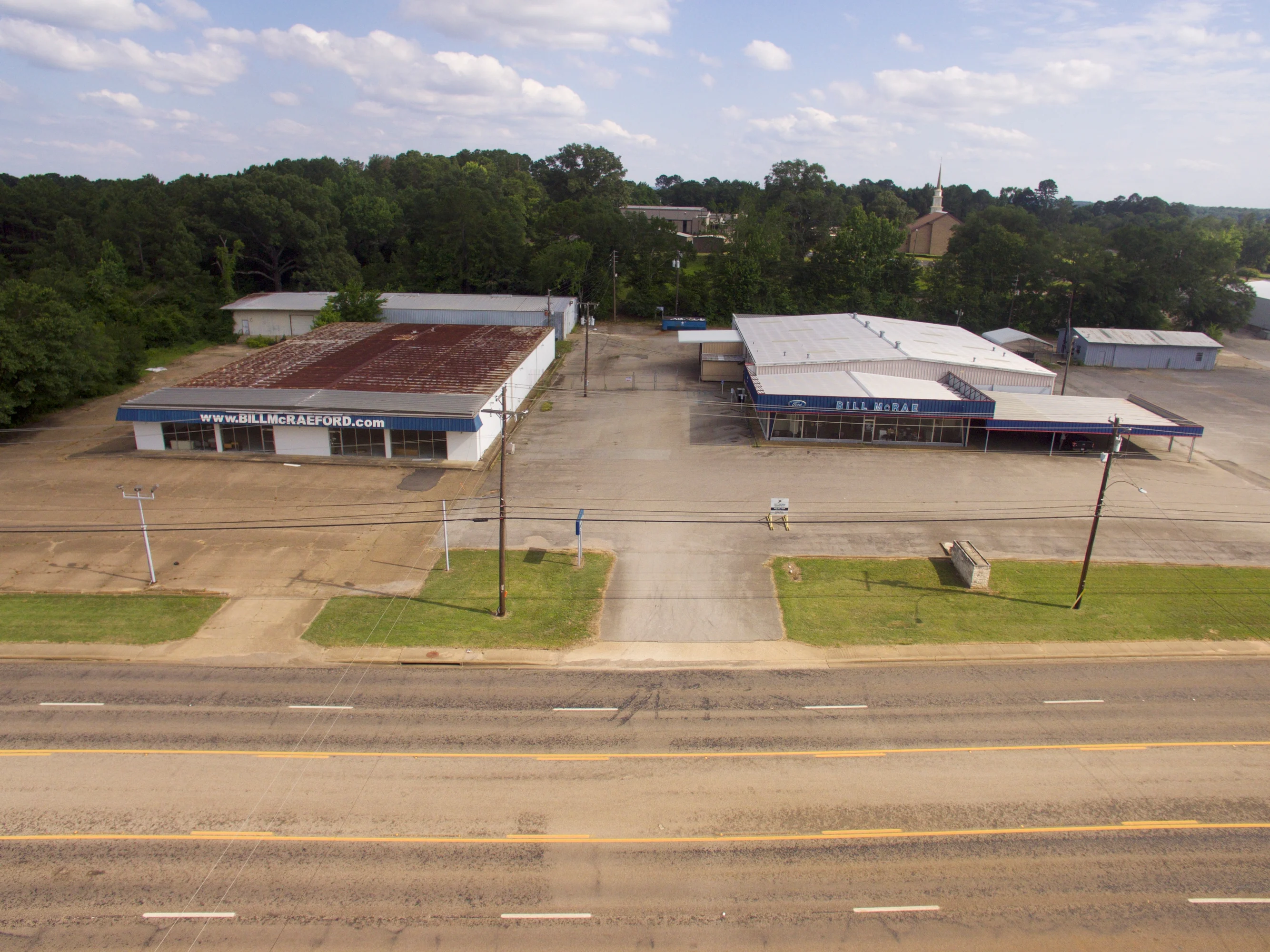 Aerial angle showing the dealership buildings, paved site area, and extensive US-79 frontage.