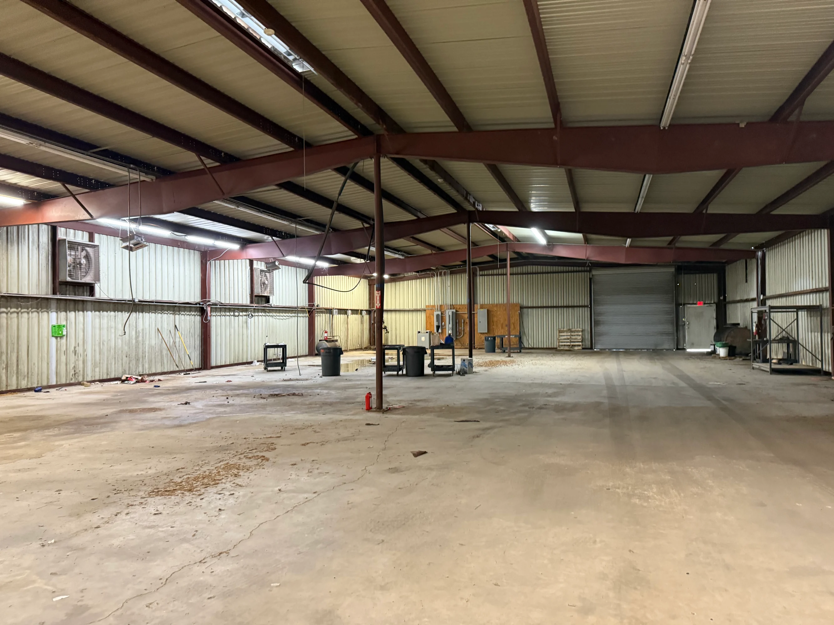 Service building with grade-level bay doors at the former dealership on E. Rusk Street.