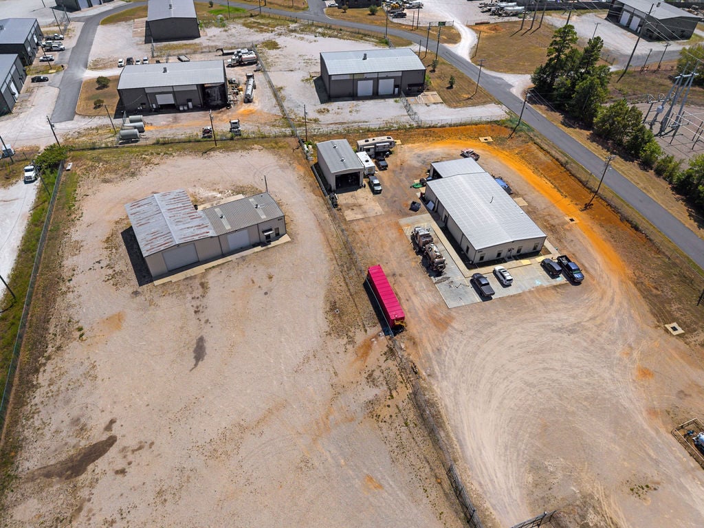 Aerial view of the smaller industrial buildings with office, metal shop and fenced service yards.