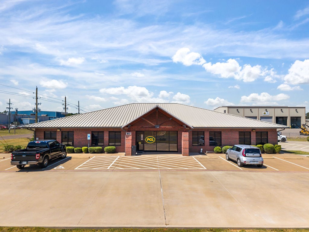 Standalone brick office building with a metal hip roof and parking lot at the Harrison Road portfolio in Longview.