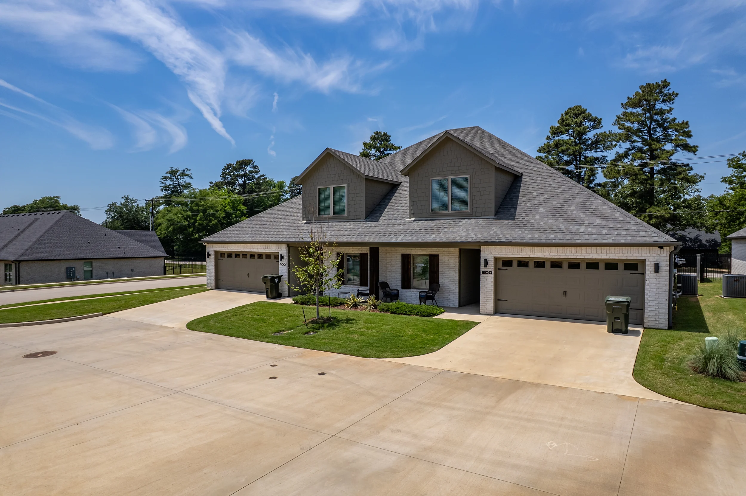 Front exterior of a modern Henshaw Creek duplex with attached two-car garages.