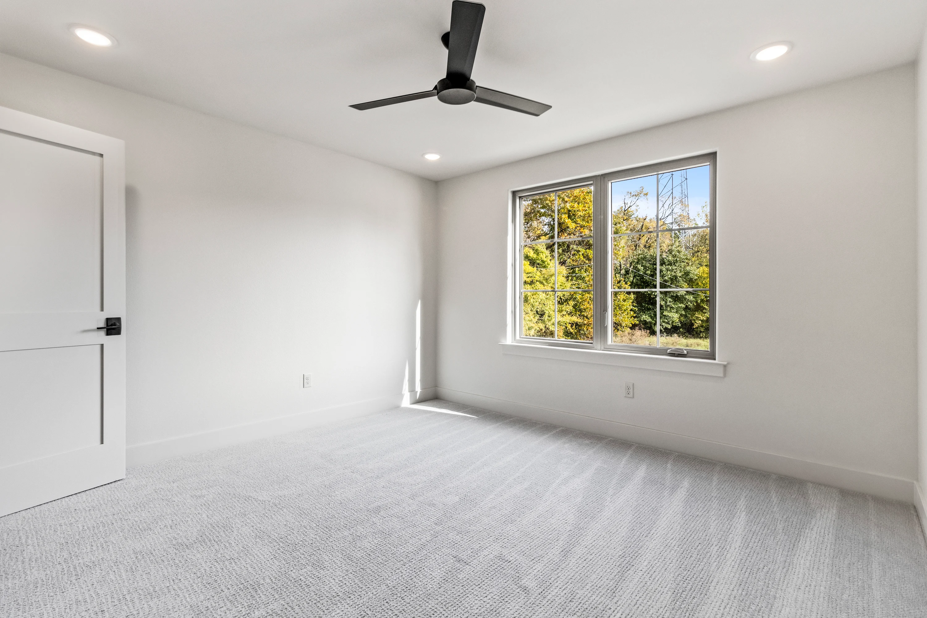 Bedroom with neutral finishes and natural light inside a Henshaw Creek duplex unit.