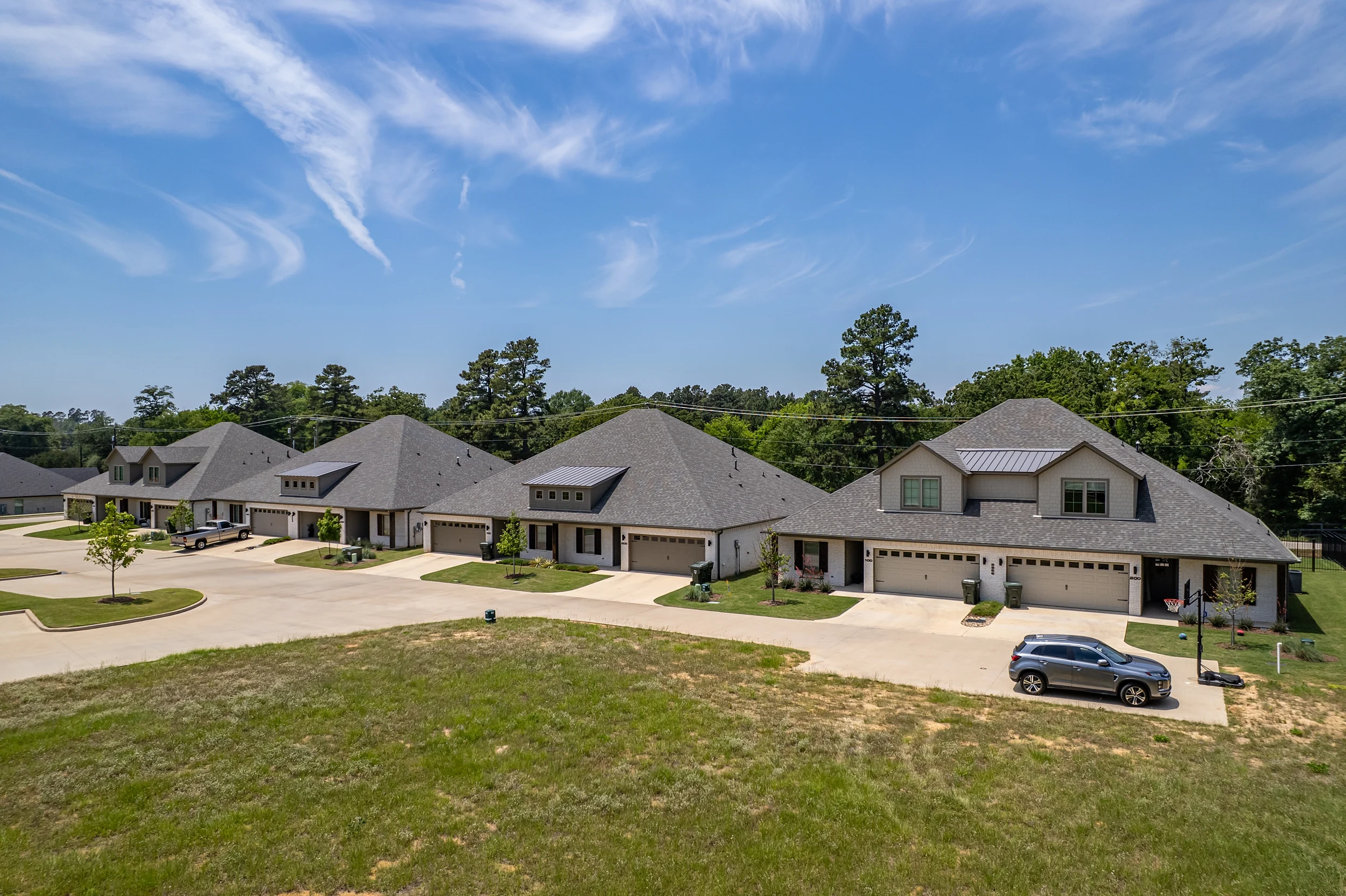 Driveways, attached garages, and additional parking serving the Henshaw Creek duplex residences.