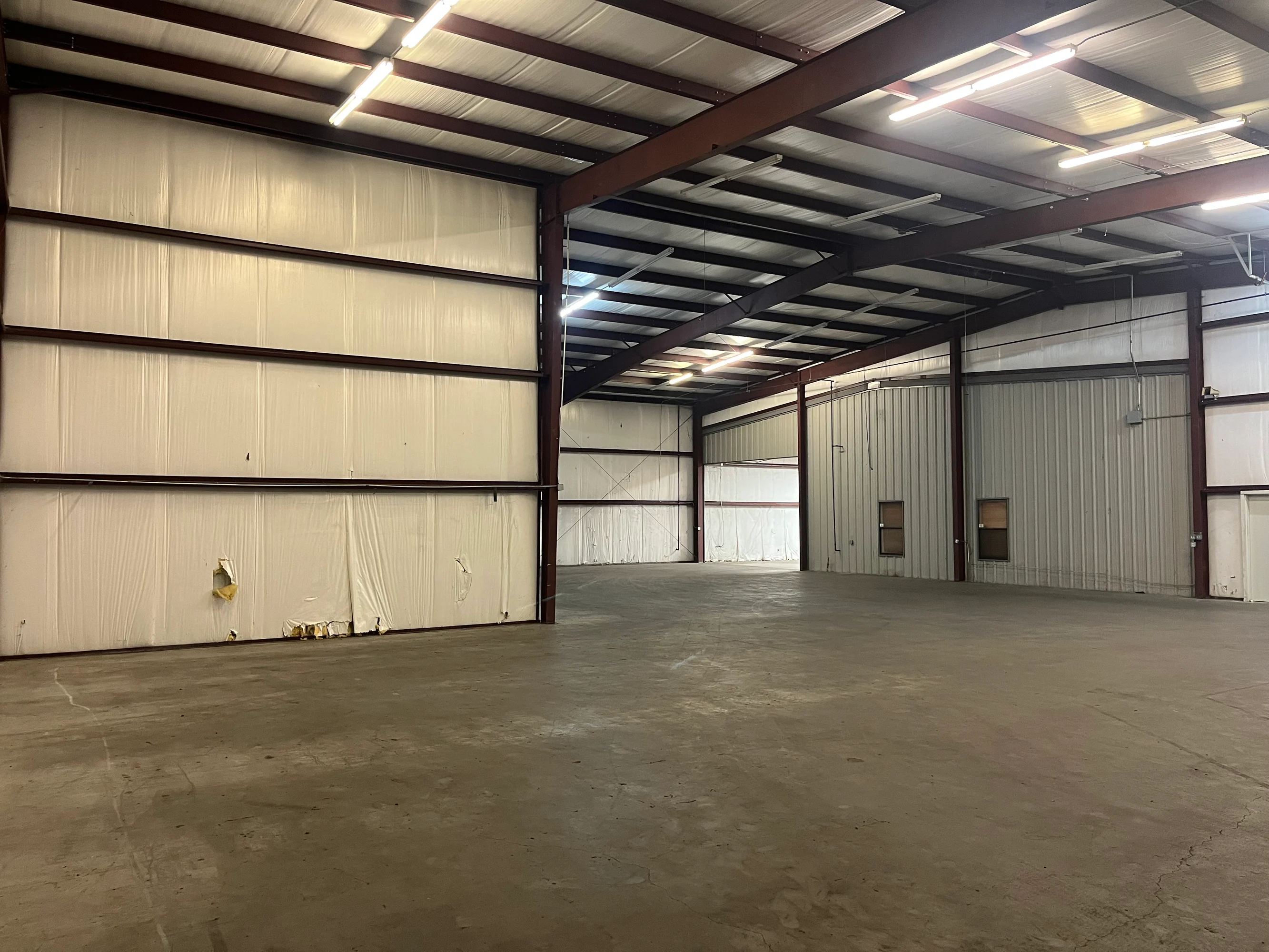 Tall open warehouse bay showing 14-20 foot clear height and insulated metal walls at Highway 110 Industrial in Tyler, Texas.