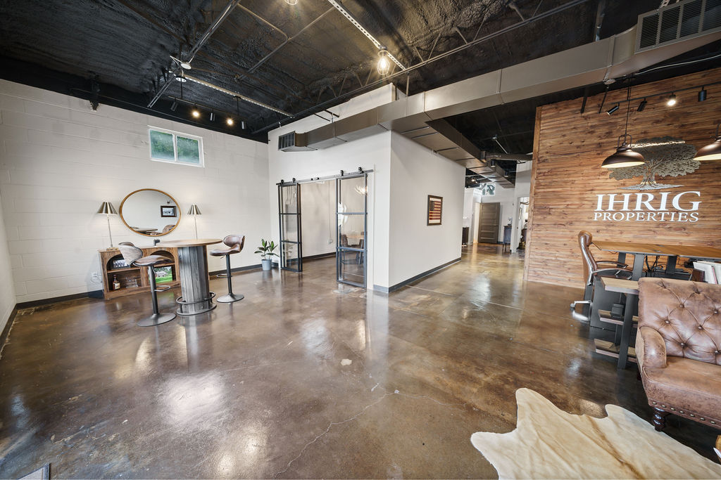 The Ihrig Properties office in Tyler, Texas, with the branded reclaimed-wood wall and open floor plan