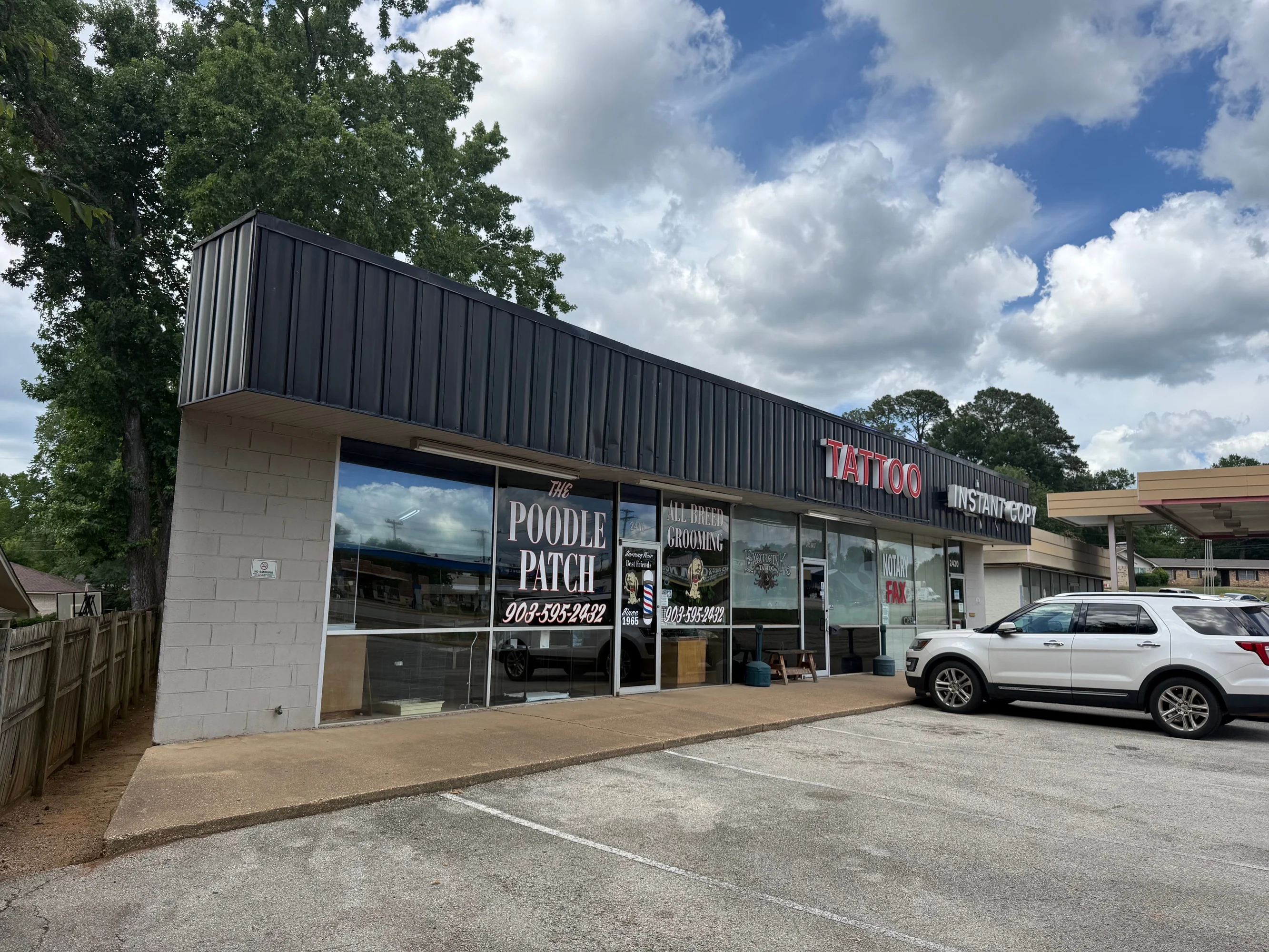 Angled exterior showing the three retail storefronts and shared parking along E. Southeast Loop 323.